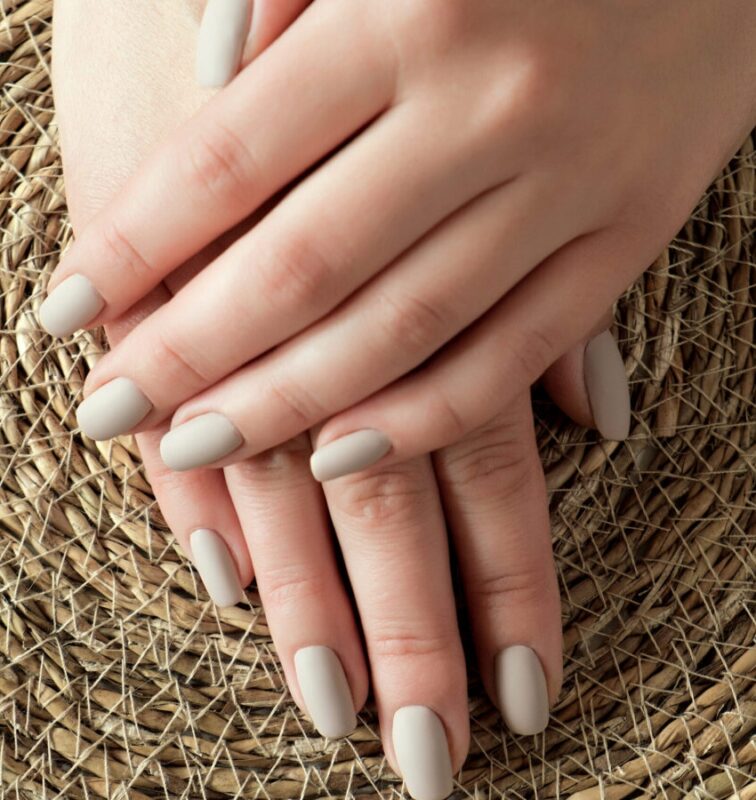 matt nude beige nails close up. winter or autumn manicure on the woman hand